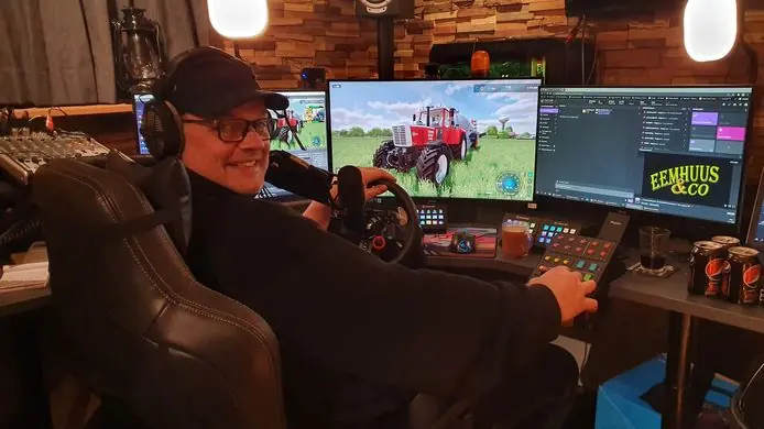 Eemhuus achter het stuur aan zijn bureau, met Farming Simulator op drie schermen
