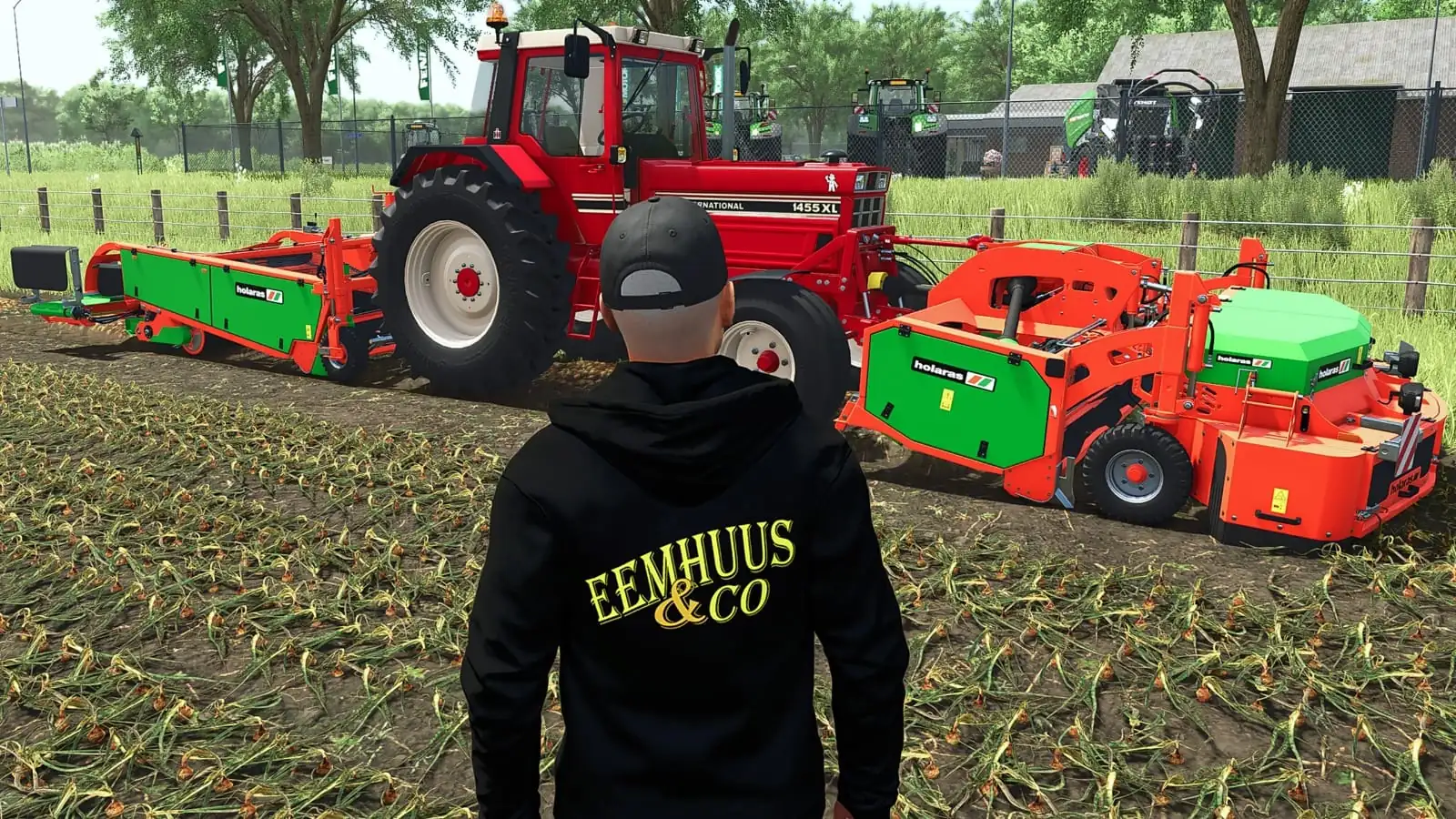 Eemhuus-hoodie op het land, met een rode International-trekker en een rooier in Farming Simulator